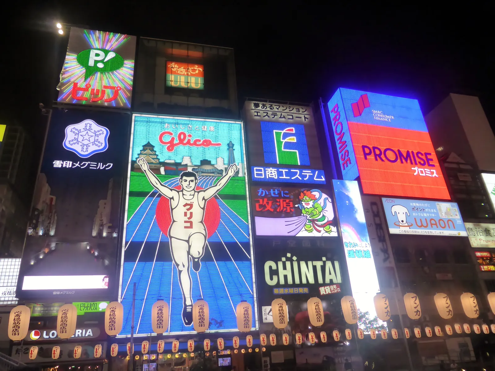 Dotonbori canal in Osaka at night, packed with neon signs and the Glico running man billboard